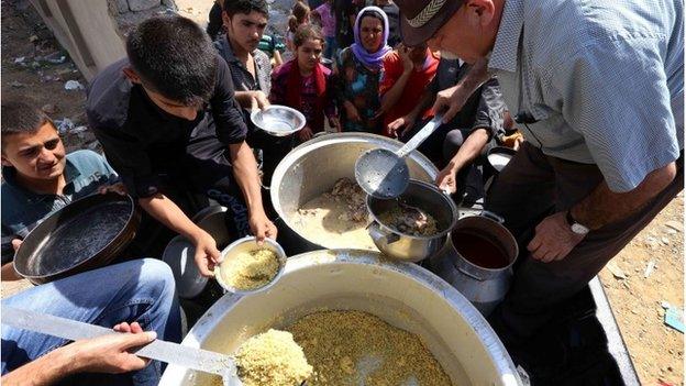 Iraqi Yazidi families receive food handouts in Dohuk in Iraq's autonomous Kurdish region (photo taken on 5 August 2014)