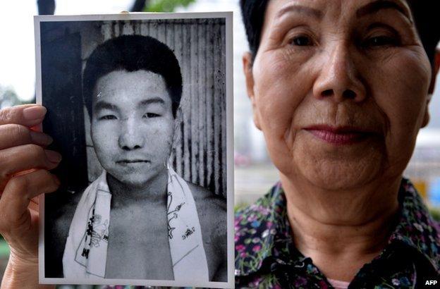 Hideko Hakamada holds a photograph of her brother Iwao as a young man