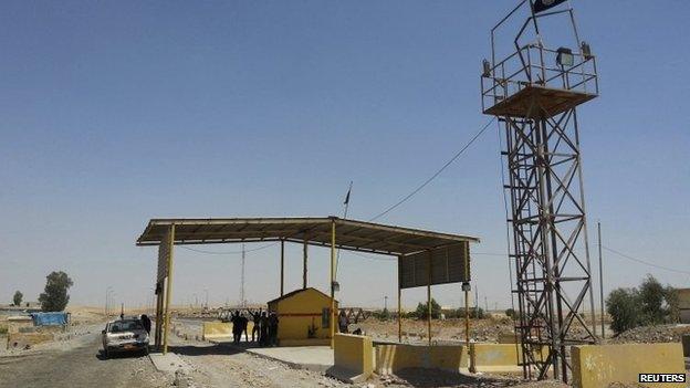 Islamic State militants stand guard after controlling a checkpoint in Khazer at the border area of the Kurdish semi-autonomous region, August 7, 2014