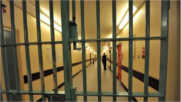 A prison corridor seen through bars