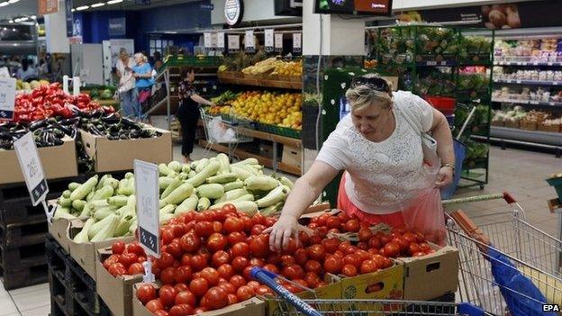 A woman chooses tomatoes in a supermarket in Moscow