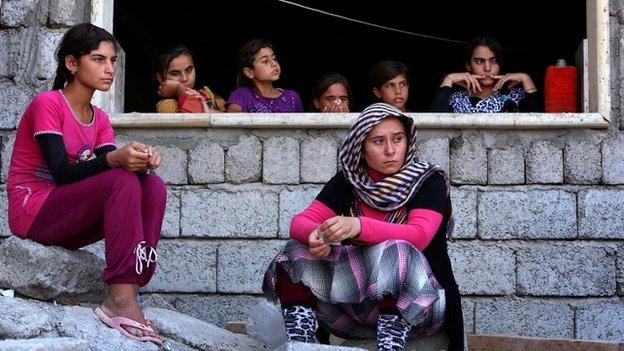 Yazidi women who fled the violence in the northern Iraqi town of Sinjar, sit at a shelter in the Kurdish city of Dohuk - 5 August 2014