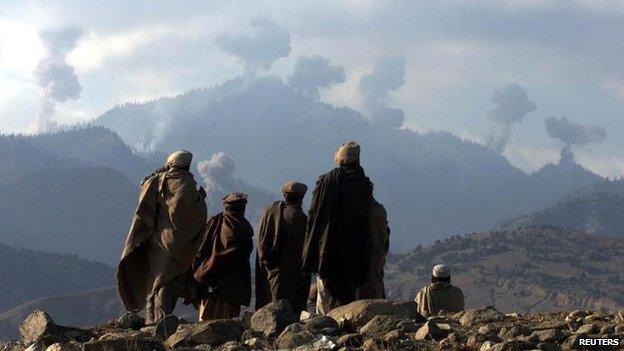 Anti-Taliban Afghan fighters watch several explosions from U.S. bombings in the Tora Bora mountains in Afghanistan in 2001