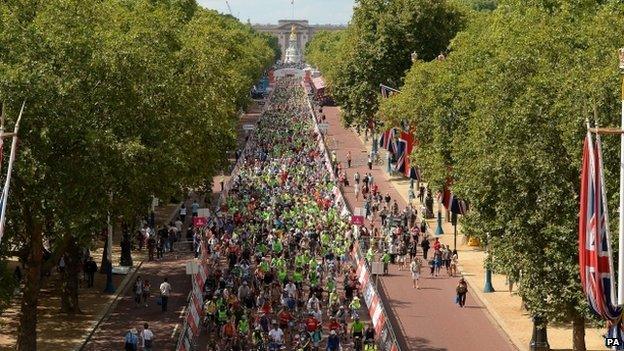 Cyclists make their way down The Mall from Buckingham Palace towards Admiralty Arch