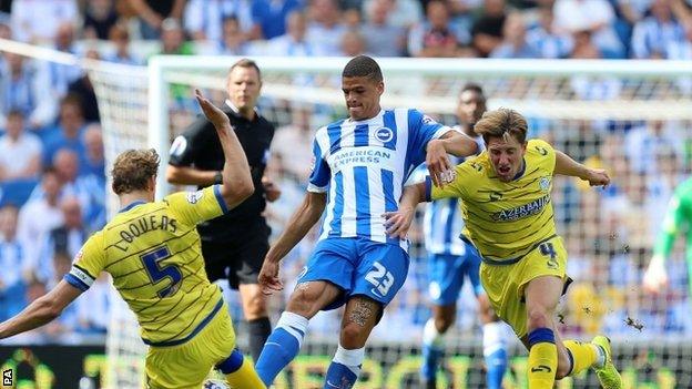 Brighton's Shamir Fenelon (centre) is challenged by Sheffield Wednesday"s Glenn Loovens (l) and Sam Hutchinson (r)