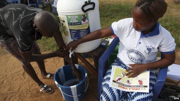 A Liberian man is encouraged to wash his hands at the Women in Peace Building Program (WIPNET) Ebola sensitisation program and prayer ground in Monrovia, Liberia 05 August