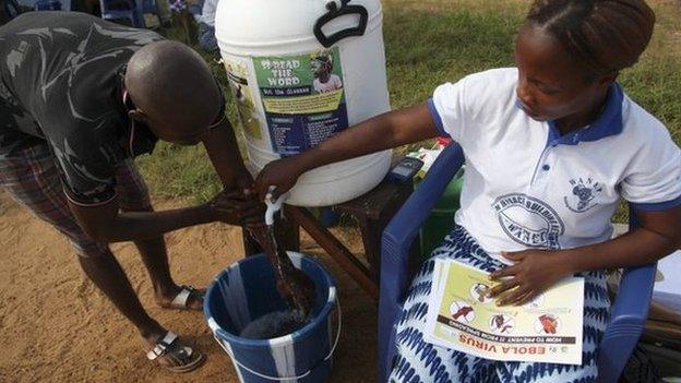 A Liberian man is encouraged to wash his hands at the Women in Peace Building Program (WIPNET) Ebola sensitisation program and prayer ground in Monrovia, Liberia 05 August