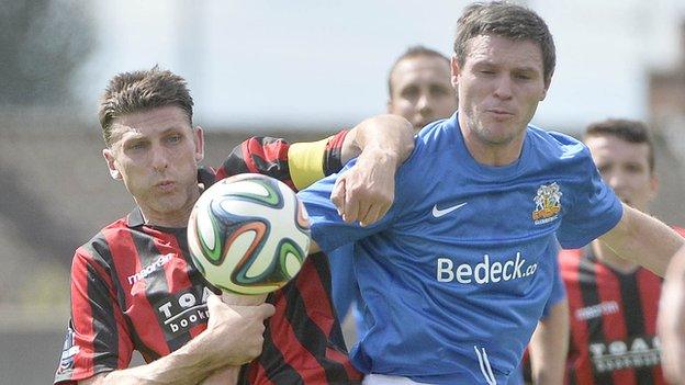 Crusaders defender Paul Leeman battles with Kevin Braniff of Glenavon