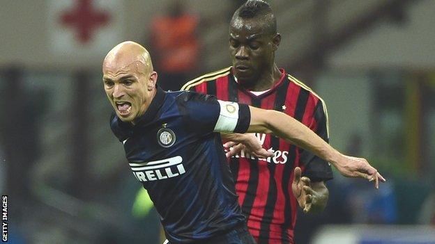 Inter Milan's Esteban Cambiasso (left) holds off AC Milan's Mario Balotelli