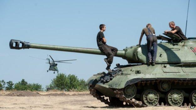 Ukrainian government soldiers sit atop of a tank in Donetsk region, eastern Ukraine, Saturday, Aug. 9