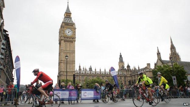 Cyclists ride past the Houses of Parliament in central London