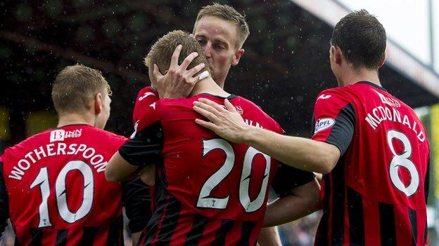 St Johnstone scorer Steven MacLean (back) plants a kiss on Scott Brown