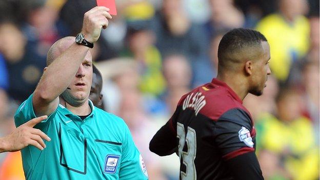 Martin Olsson is shown a red card by referee Stuart Hooper