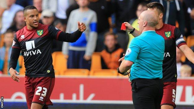 Martin Olsson is shown a red card by referee Stuart Hooper