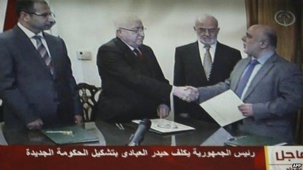 Iraqi President Fuad Masum (2nd L) shakes hands with deputy parliamentary speaker Haidar al-Abadi who has been tasked with forming a government ( image from Iraqi state TV)