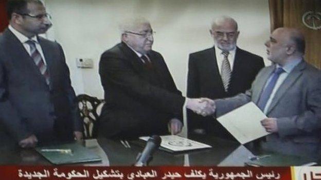 Iraqi President Fuad Masum (2nd L) shakes hands with deputy parliamentary speaker Haidar al-Abadi who has been tasked with forming a government ( image from Iraqi state TV)
