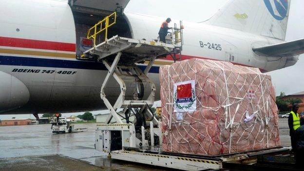 Workers unload medical supplies, coming from China and worth 4.9 million USD (around 3,7 million euro), for countries hit by the Ebola outbreak from an airplane at the Conakry airport on 11 August 2014.