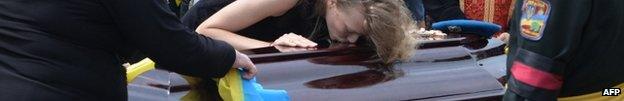 A woman kisses the coffin of a Ukrainian soldier killed fighting in the east, at his funeral in Lviv, 7 August