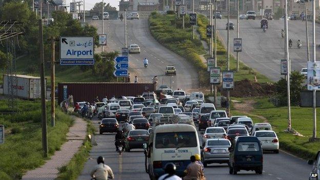 Pakistani authorities place containers on the road leading to Islamabad to stop activists