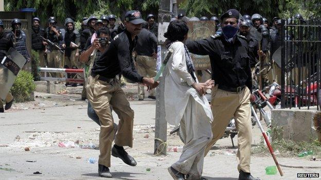 Policemen detain a supporter of Muhammad Tahirul Qadri, Sufi cleric and leader of political party Pakistan Awami Tehreek, during a protest in Lahore (17 June 2014)