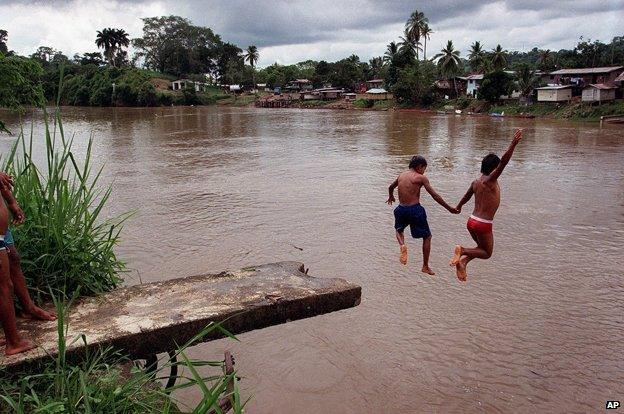 Two boys diving from a platform into the Darien Gap at Yaviza