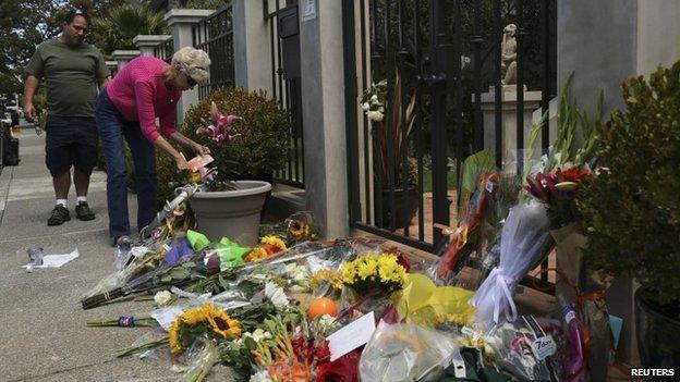 A woman places flowers and a card outside the home of actor Robin Williams in Tiburon, California 12 August 2014