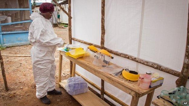 A healthcare worker prepares Ebola personal protective equipment before entering the Ebola isolation ward at Kenema Government Hospital, in Kenema, Sierra Leone, 12 August, 2014