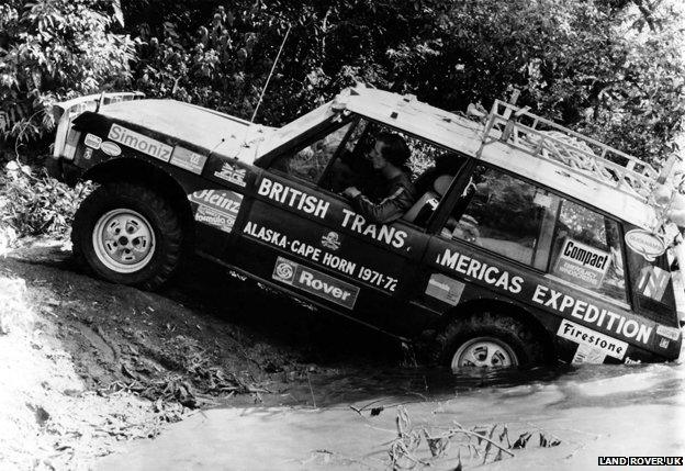 Landrover being driven out of water in jungle