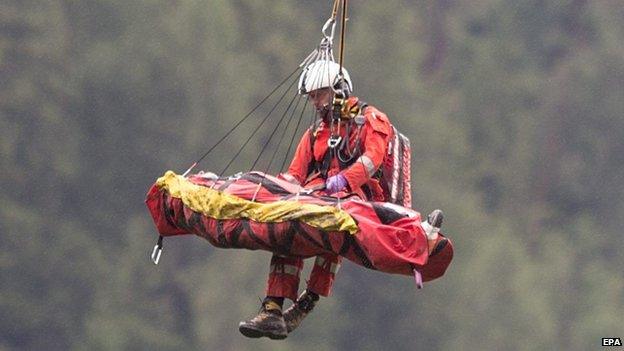 Rescue services airlift a victim of the passenger train accident near Tiefencastel, Switzerland, 13 August 2014