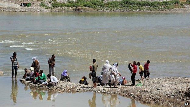 Yazidis wash themselves in the Tigris River at Fishkhabour, northern Iraq on 10 August 2014