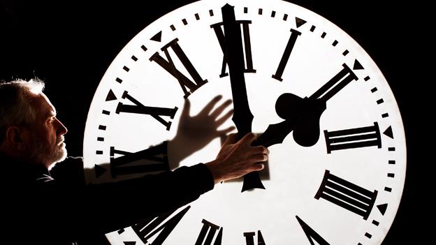 Director of James Ritchie & Son clockmakers adjusts a clock face to British Summer Time in Edinburgh