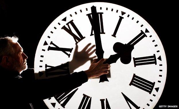 Director of James Ritchie & Son clockmakers adjusts a clock face to British Summer Time in Edinburgh