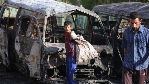 Iraqis check out the aftermath of a car bomb in Baghdad