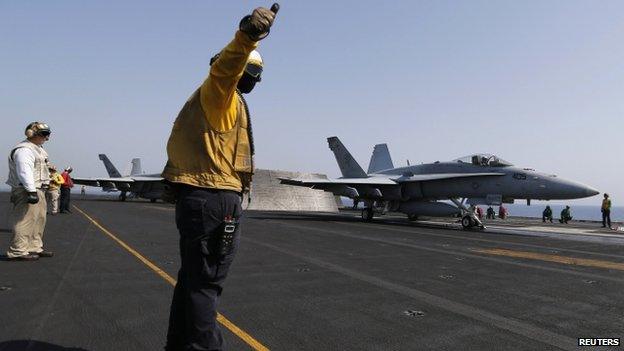 Flight deck crew member gives a thumbs up to take off to pilot of aircraft aboard USS George H W Bush (12 August 2014)