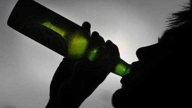 Young person drinking from beer bottle