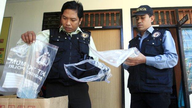 Indonesian forensic police officers view evidence related to the death of an American woman at a police station in Bali, Indonesia, on Wednesday, 13 August, 2014