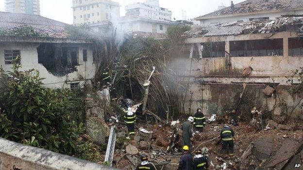 Firefighters work where a private jet carrying Brazilian presidential candidate Eduardo Campos crashed in Santos on 13 August, 2014.