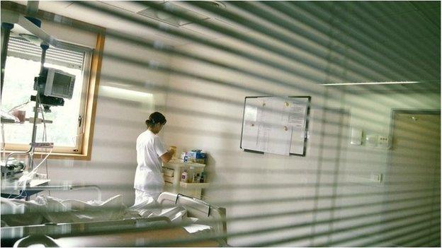 Nurse at a workstation in a patient's room in a hospital