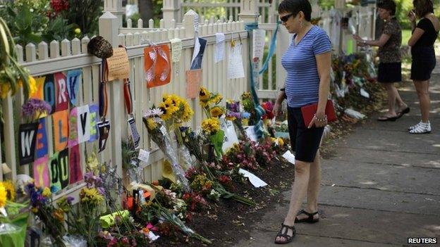 A woman looks at an impromptu memorial to actor Robin Williams outside the house used in his breakout hit TV show "Mork and Mindy" in Boulder, Colorado 13 August 2014