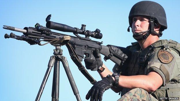 A St Louis police officer holds a sniper rifle.