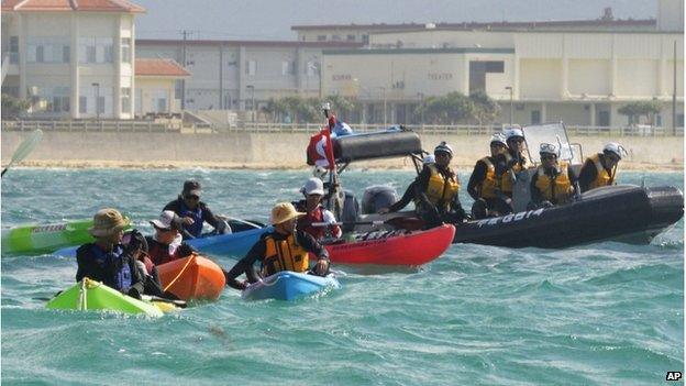 Anti US base protesters in canoe are blocked by a Japan Coast Guard speed boat in Nago, Okinawa, southern Japan, Thursday, 14 Aug 2014