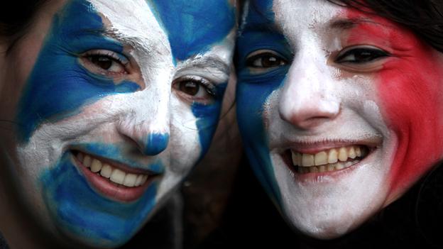 Two people face-painted with Scottish and French flags