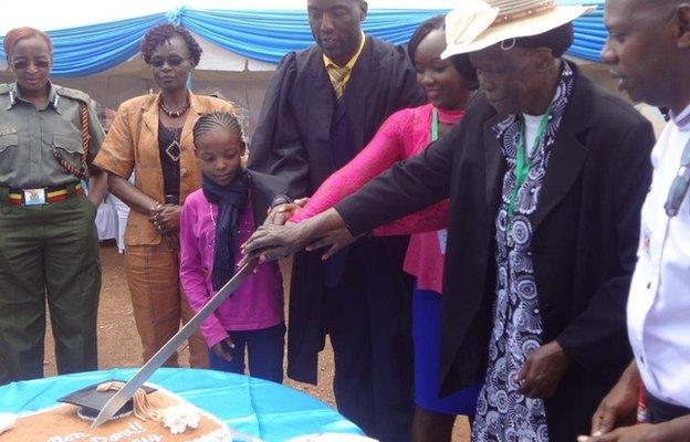 Peter Ouko, his daughter and mother cut a giant cake make for his graduation, Kamiti prison in Nairobi, Kenya - Friday 15 August 2014