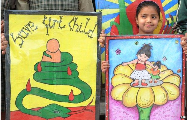 Indian schoolgirls pose with placards during a protest march against female foeticide in Amritsar on March 23, 2012.