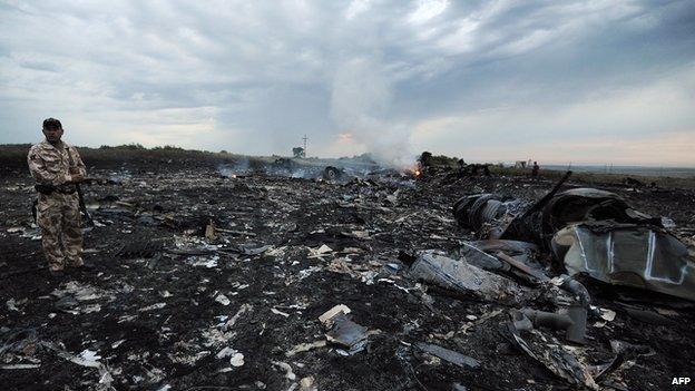 A man stands in the debris of MH17