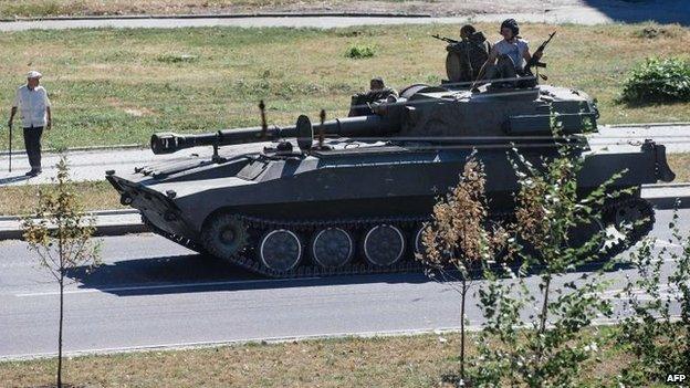 A pro-Russian militia tank moves along a street in Donetsk, 15 Aug