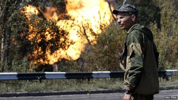 A pro-Russian rebel looks on as a gas pipeline is ruptured by shelling in Donetsk, 15 Aug