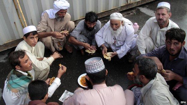 Supporters of Tahirul Qadri, a Pakistani-Canadian cleric, have a meal after they arrived to attend a protest march in Islamabad, Pakistan, 16 August 2014