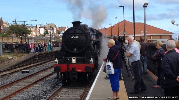 People waiting at the platform for steam train