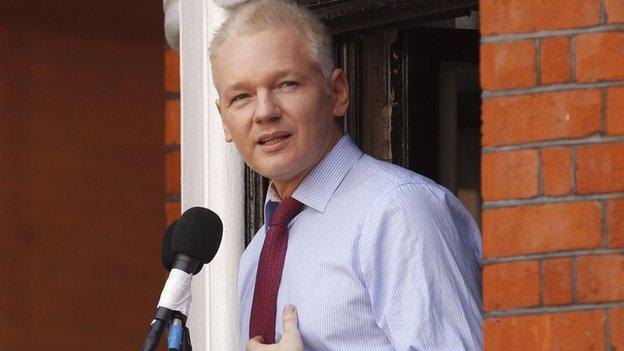 Julian Assange reads a statement to the media from the window of the Ecuadorean embassy